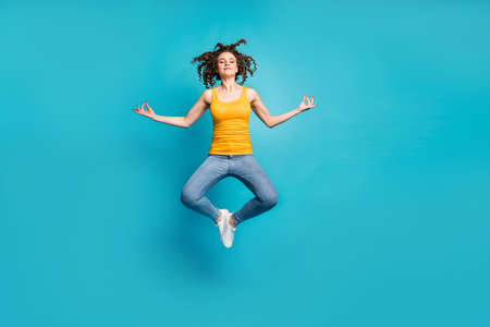 Full length photo of calm tranquil lady jump high practicing morning yoga isolated blue color backgroundの写真素材