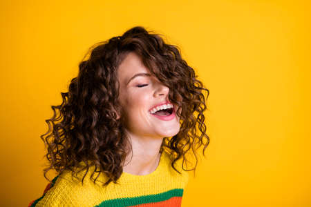 Photo of sweet laughing lady wearing casual colorful sweater closed eyes isolated yellow color backgroundの写真素材