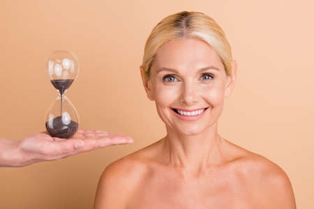 Portrait of harmony middle aged woman enjoy skincare spa salon procedure sandglass clock isolated...