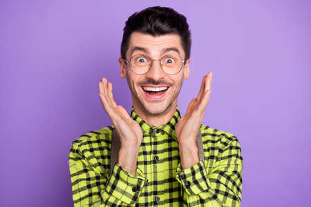Photo portrait of amazed man with open mouth showing palms isolated on vivid violet colored...
