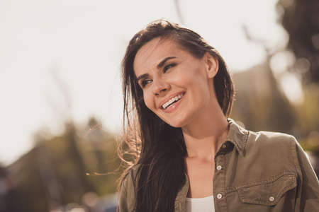 Photo portrait of cute dreamy girl smiling looking in distance thinking about future outdoorsの写真素材