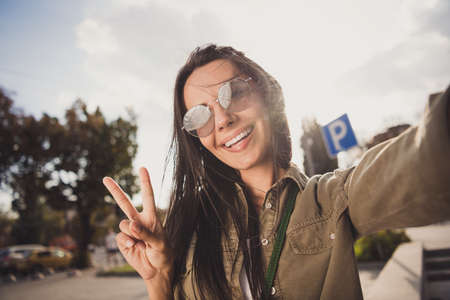 Photo of pretty lovely young woman dressed brown shirt eyewear smiling recording video showing...