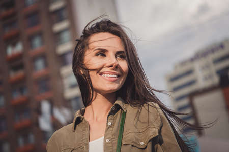 Photo of charming pretty young lady wear brown shirt smiling walking looking side outside sunny...