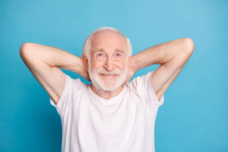 Portrait of handsome person arms behind head look up empty space enjoy weekend isolated on blue...