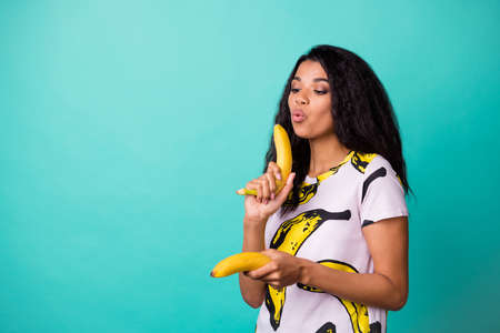 Photo of cool dark skin girl blow air banana gunshot finish concept isolated over teal color backgroundの写真素材