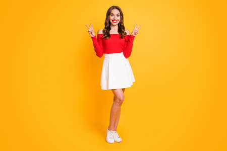 Full length body size photo of amazed girl showing peace v-sign gesture smiling isolated on vibrant...
