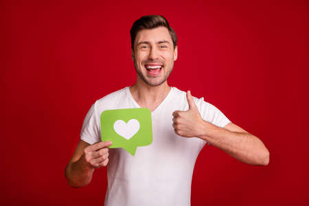 Portrait of cheerful person toothy smile show thumb up hold paper like card isolated on maroon color...