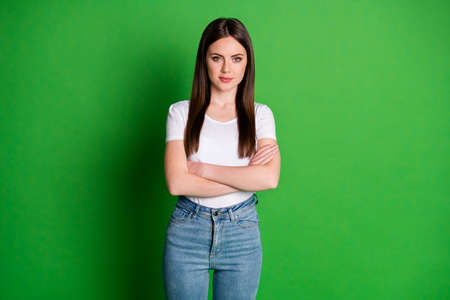 Photo of cute confident woman dressed casual outfit arms folded isolated green color backgroundの写真素材