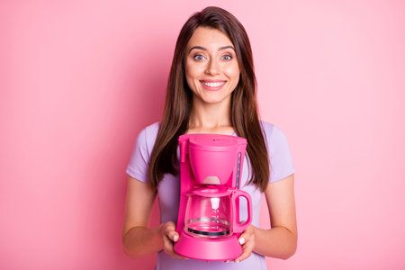 Close-up portrait of nice-looking young lady hold coffee maker dressed casual outfit isolated on pink color backgroundの写真素材