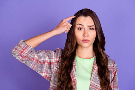 Photo of young doubtful minded woman scratch finger head raise eyebrow isolated on violet color...