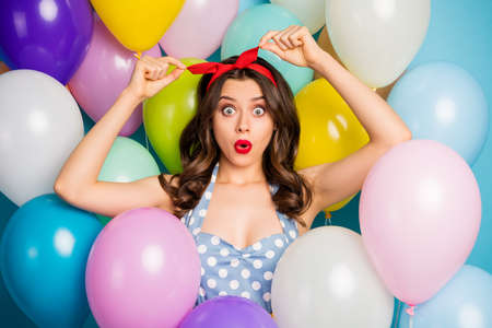 Close up photo of astonished girl look in mirror impressed her haircut scream wow omg start fix red headband wear vintage singlet on air balls baloons backgroundの写真素材