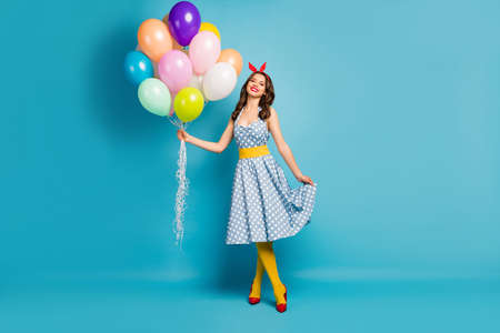 Full length body size view of her she nice-looking attractive lovely feminine cheerful wavy-haired girl holding air balls posing having fun isolated on bright vivid shine vibrant blue color backgroundの写真素材