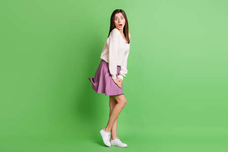 Full size profile side photo of young attractive beautiful shocked amazed girl with open mouth isolated on green color backgroundの写真素材