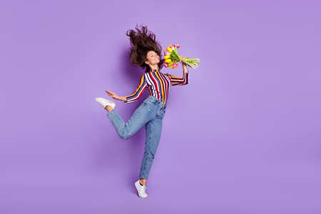 Full length body size photo of woman jumping gracefully smelling scent of flowers smiling isolated...