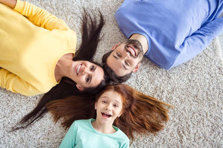 Top above high angle view photo of young happy funky smiling family mommy daddy and little daughter...