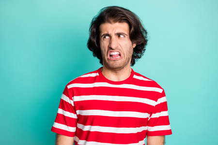 Portrait of nice funky tired capricious brown-haired guy looking aside grimacing isolated over...