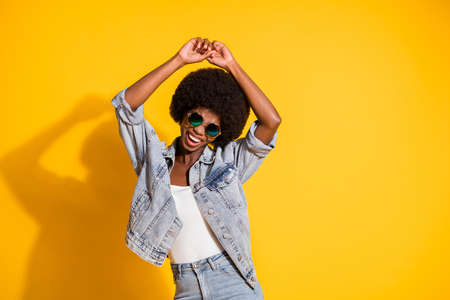 Photo of shiny young woman wear casual jeans clothes dancing enjoying music isolated yellow color backgroundの写真素材