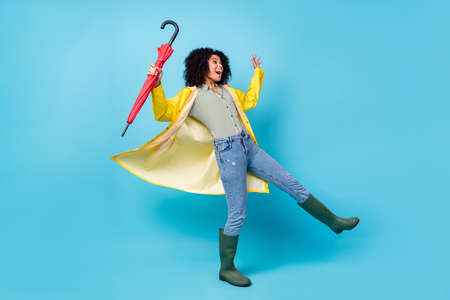 Photo of pretty funky dark skin lady wear yellow overcoat walking holding parasol looking empty...