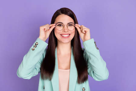 Photo of young happy smiling positive smart businesswoman manager in glasses isolated on purple color backgroundの写真素材