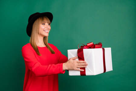 Photo of young lovely pretty happy cheerful smiling girl give gift present in copyspace isolated on...