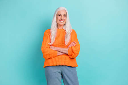 Portrait of attractive cheerful grey-haired woman folded arms wearing cozy clothes isolated over...