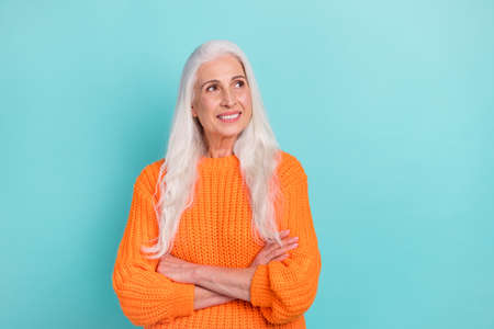 Portrait of attractive creative cheerful grey-haired woman folded arms thinking copy space isolated...