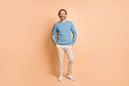 Full length photo of cool business man wear specs blue pullover trousers footwear isolated beige color backgroundの写真素材