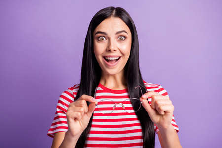 Photo of amazed cheerful happy woman hold glasses unbelievable discount isolated on purple color backgroundの写真素材