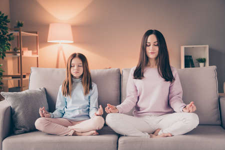 Full body portrait of focused pretty lady adorable girl closed eyes fingers hands meditate free time indoorsの写真素材
