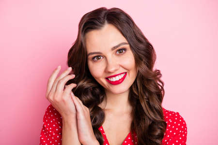 Portrait of nice optimistic brown hair lady hold hands wear red dress isolated on pastel pink color backgroundの写真素材