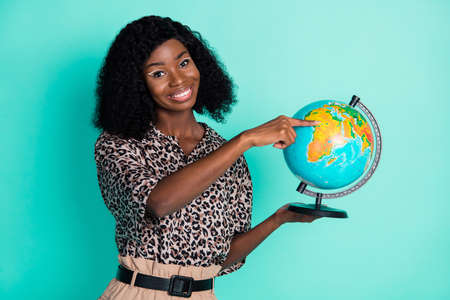 Photo of lovely promoter lady hold globe touch finger wear leopard print shirt isolated turquoise color backgroundの写真素材