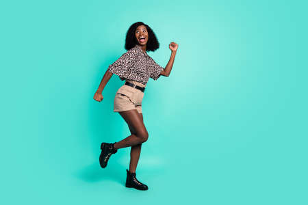 Photo of funky lady run look empty space wear leopard print shirt shorts boots isolated turquoise...