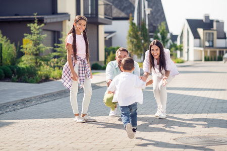 Full size photo of happy smiling excited cheerful family mom and dad wait their little son go with open hands sister stand and watchの写真素材