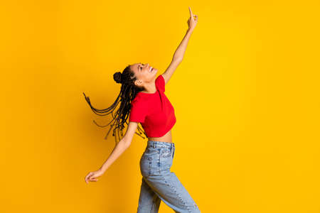 Profile side view portrait of pretty cheerful girl enjoying dancing having fun chill isolated on bright yellow color backgroundの写真素材