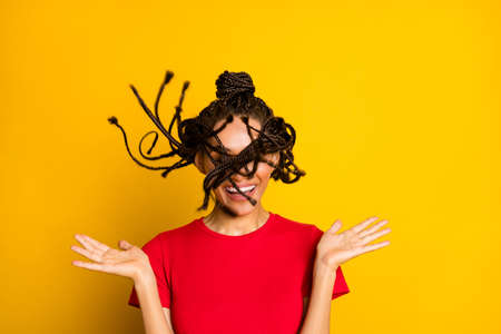 Portrait of attractive funny cheeeful careless girl throwing hair having fun isolated on bright yellow color backgroundの写真素材