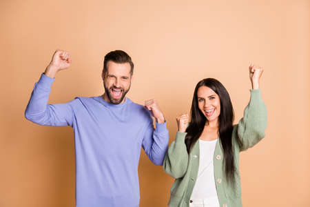 Photo of hooray couple hands fists wear sweater yell isolated on beige color backgroundの写真素材