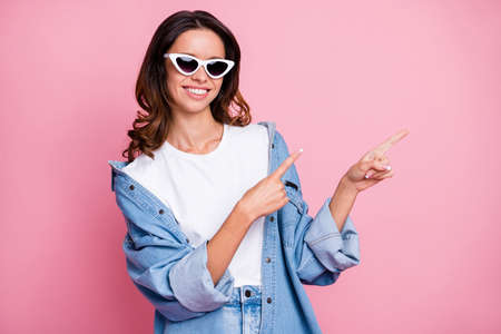 Photo of happy positive woman point empty space subscribe index finger isolated on pink color backgroundの写真素材