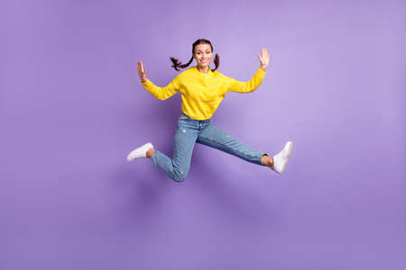 Photo of sweet charming young woman braids wear yellow pullover jumping high isolated purple color...
