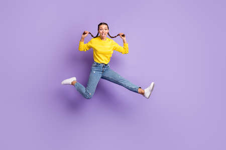 Full body photo of excited young girl jump arms hold play with hair tails tongue out isolated on...