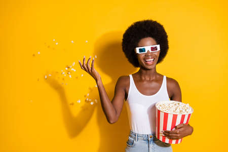 Portrait of nice cheerful wavy-haired girl eating throwing corn having fun good mood watching film...