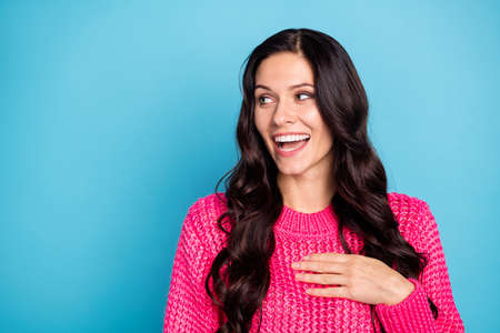 Portrait of attractive cheerful wavy-haired girl looking aside laughing copy space ad isolated over vivid blue color backgroundの写真素材