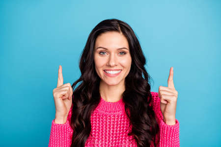 Portrait of attractive cheerful wavy-haired girl pointing forefingers up copy space ad isolated over...