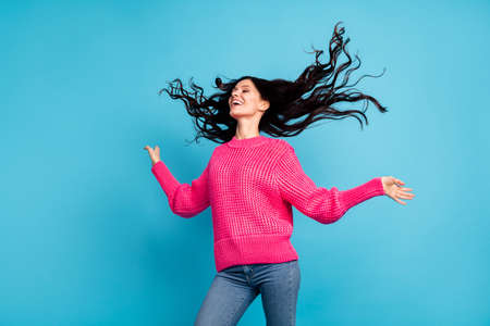 Photo of carefree happy woman fly hair look empty space wear casual outfit isolated on blue color backgroundの写真素材