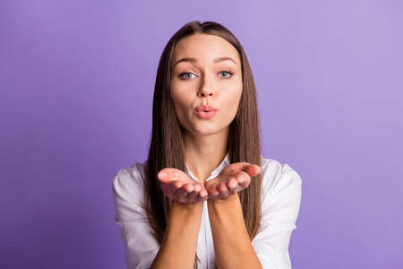 Photo of lovely adorable girl send air kiss you look camera wear white shirt isolated purple color backgroundの写真素材
