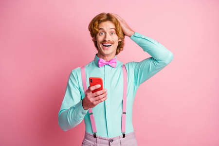 Photo of young amazed happy positive man hold hand head sees unexpected post comment isolated on...