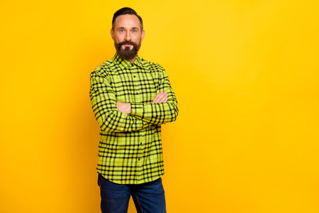 Photo of handsome man serious confident folded hands wear casual outfit isolated over yellow color backgroundの写真素材