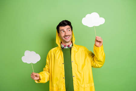 Photo of young cheerful man happy positive smile look cloud stick wet weather forecast isolated over green color backgroundの写真素材