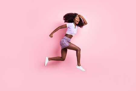 Full length body size view of beautiful trendy energetic cheerful girl jumping running finding way direction isolated on pink pastel color backgroundの写真素材