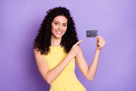 Photo of positive lady indicate finger debit banking card proposition isolated on violet color backgroundの写真素材