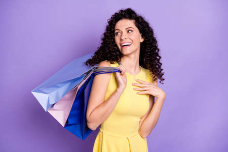 Photo of adorable positive lady look interested empty space arm on chest isolated on violet color backgroundの写真素材